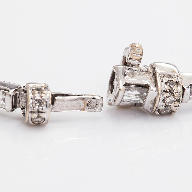 An 18K white gold bracelet set with baguette and brilliant-cut diamonds.