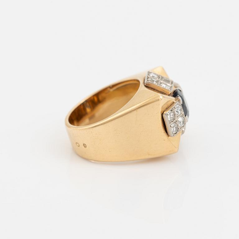 An 18K gold ring set with a faceted sapphire and diamonds.