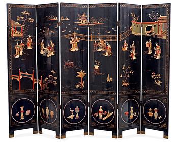 1479. A chinese black lacquer six-panel screen, early 20th Century, with figures in gardens, inlays of carved mother of pearl, coloured bone, tree, and different stones. Back of panels with flowers painted in gold.