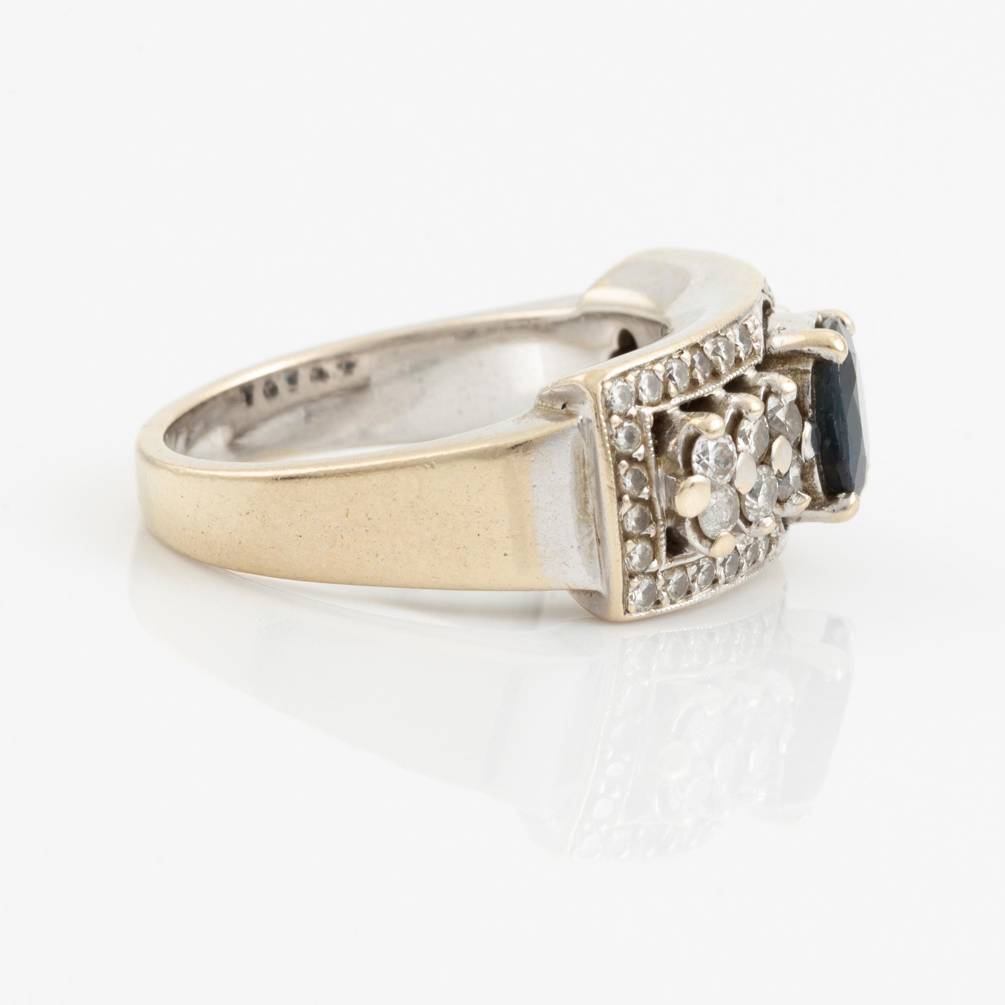 Ring with dark sapphire and brilliant-cut diamonds.