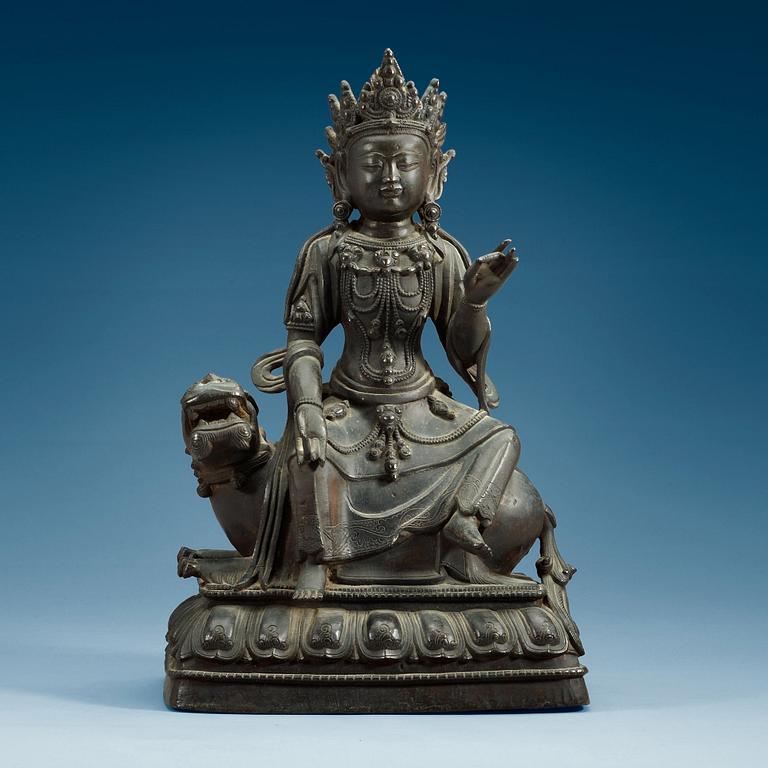 A large bronze figure of Bodhisattva seated on a mythical beast, Qing dynasty, 18/19th Century.