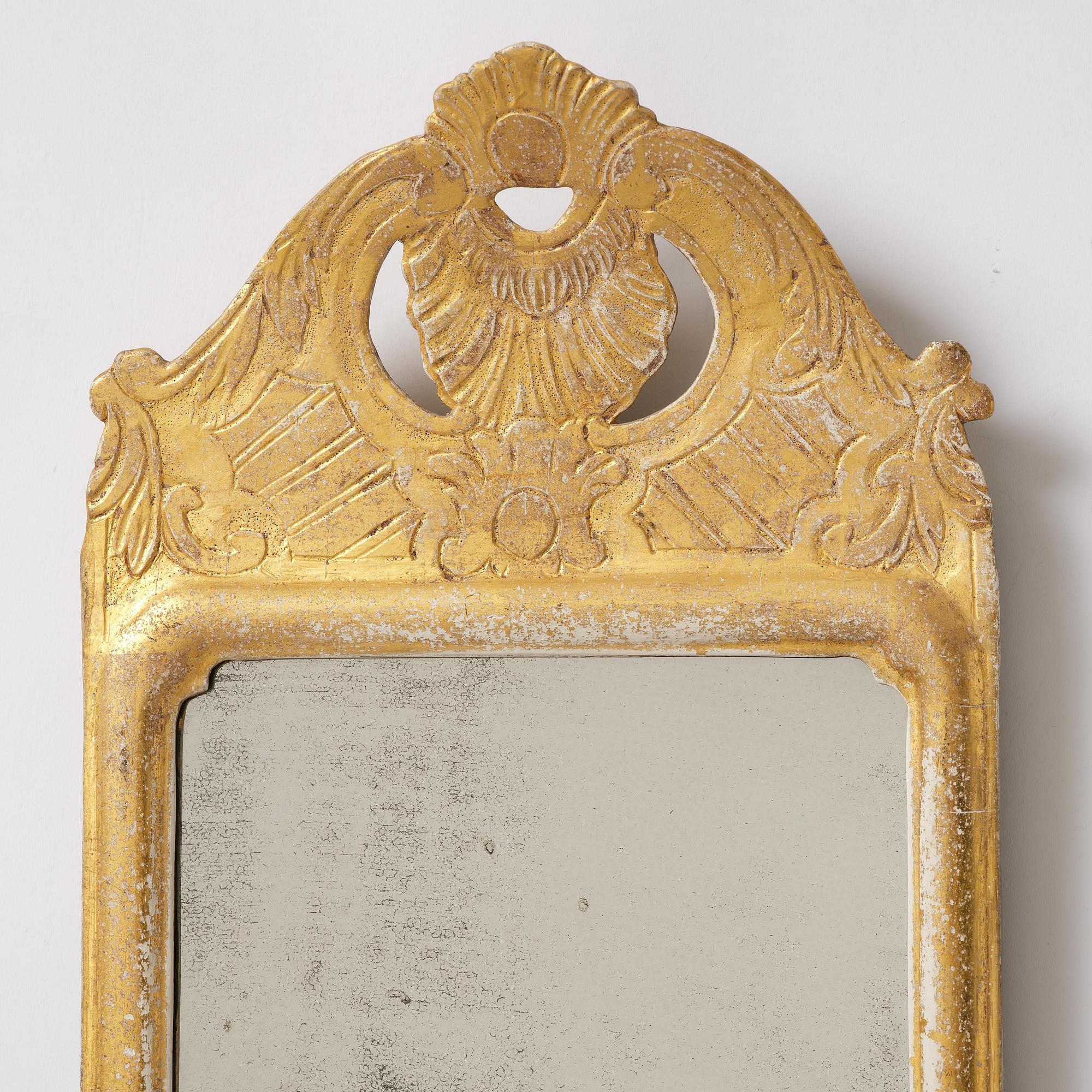 A matched pair of rococo giltwood one-branch girandole mirrors, Stockholm, late 18th century.