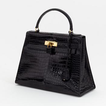 1962 black alligator 'Kelly' handbag by Hermès.