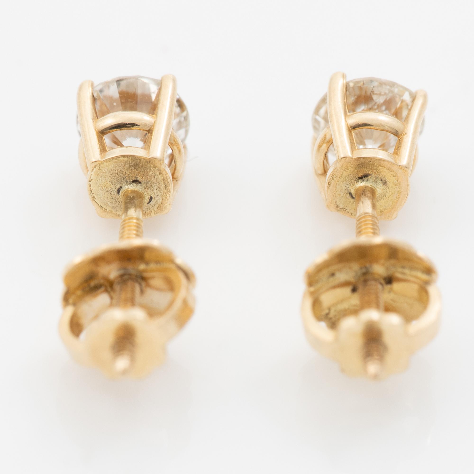 A pair of 14K gold earrings with round brilliant-cut diamonds.