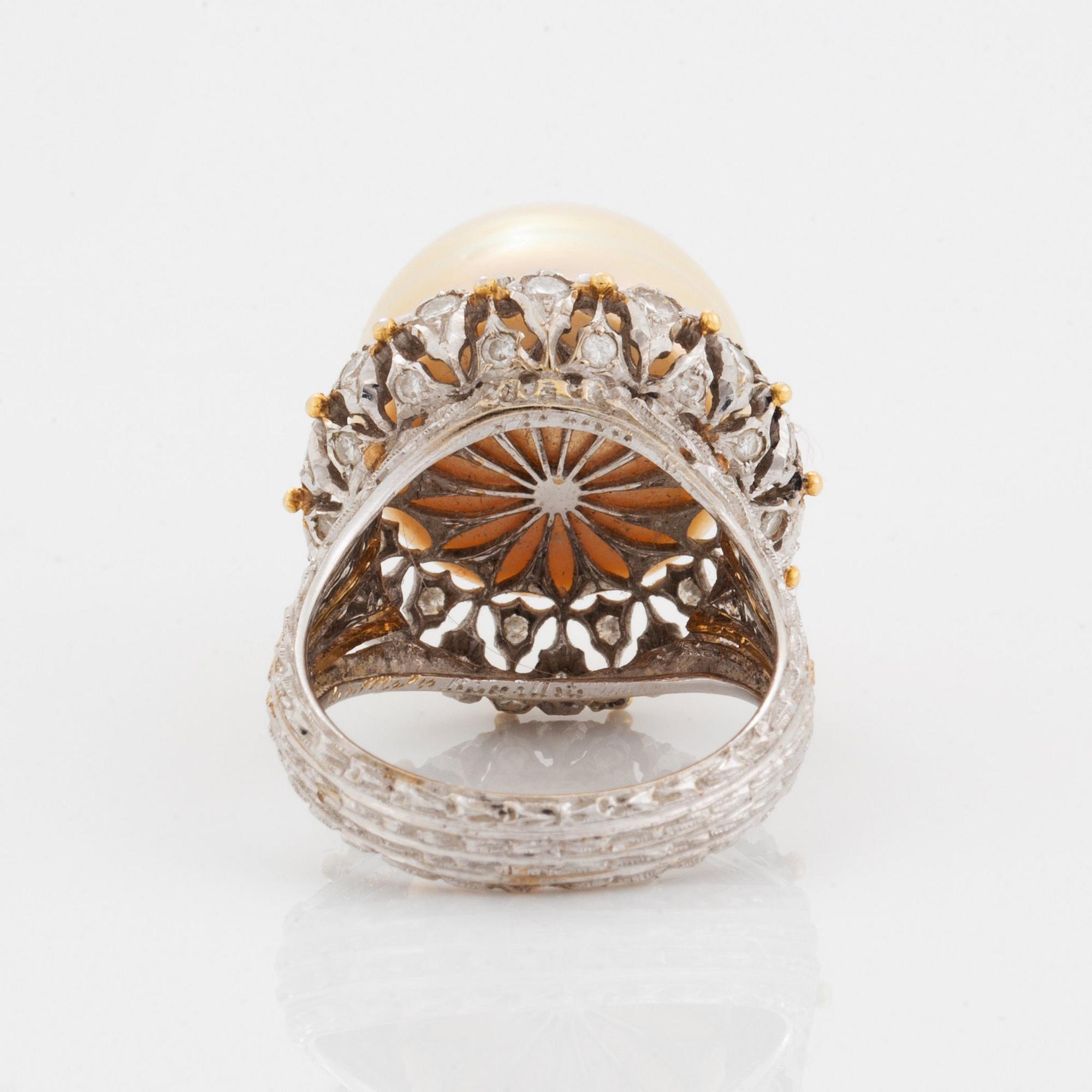 An 18K gold ring set with a cultured pearl and round brilliant-cut diamonds.