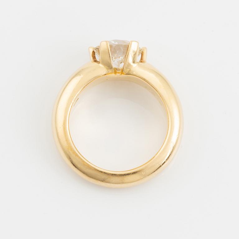 An 18K gold ring set with a round brilliant-cut diamond.