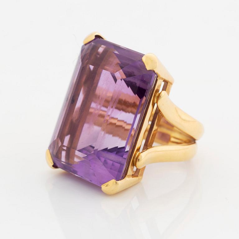 A Tina Karlsson ring in 18K gold set with a faceted amethyst.