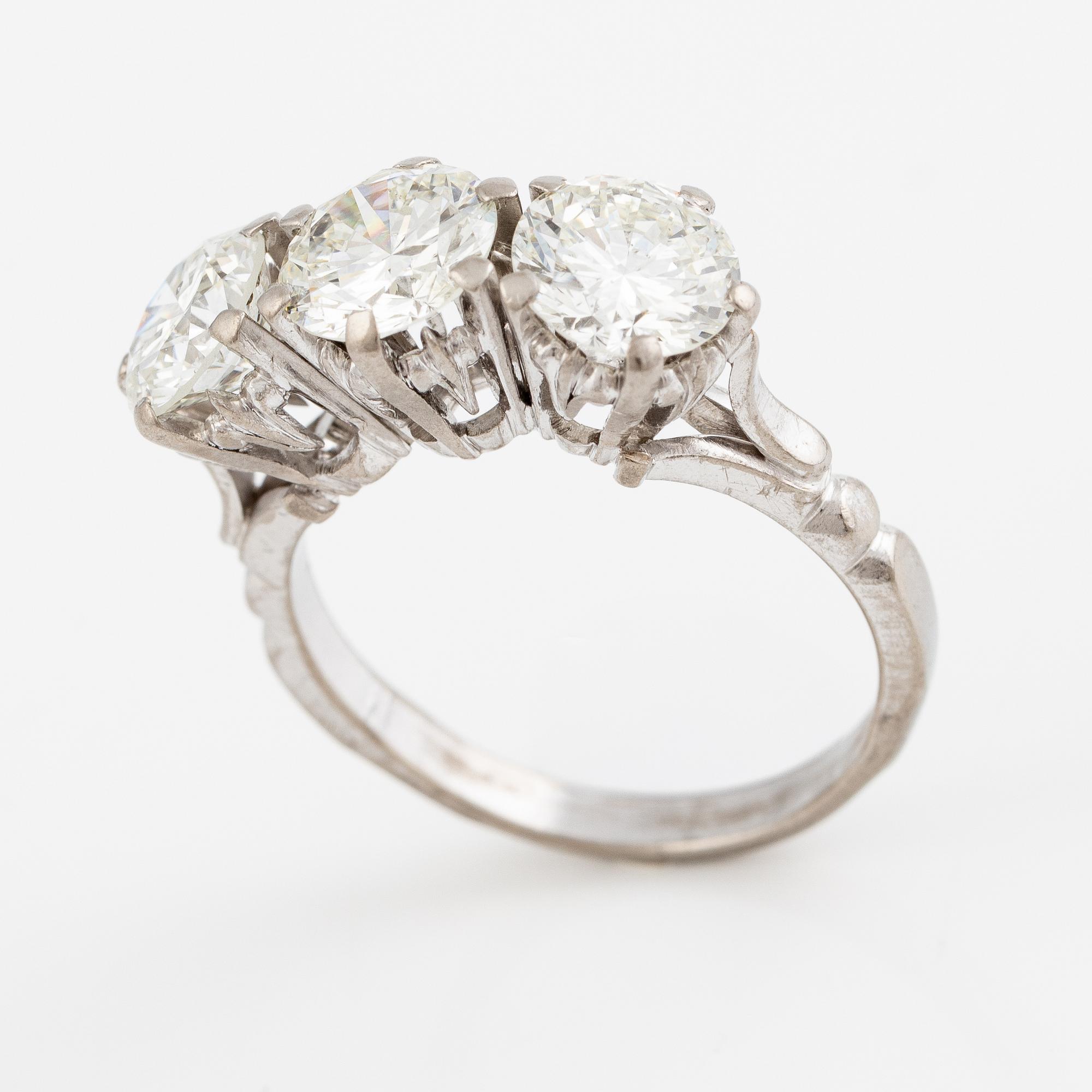 Ring, trestensring, 18K vitguld med tre briljantslipade diamanter.