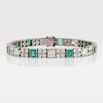 1148. A platinum bracelet set with round brilliant- and old-cut diamonds and faceted emeralds.