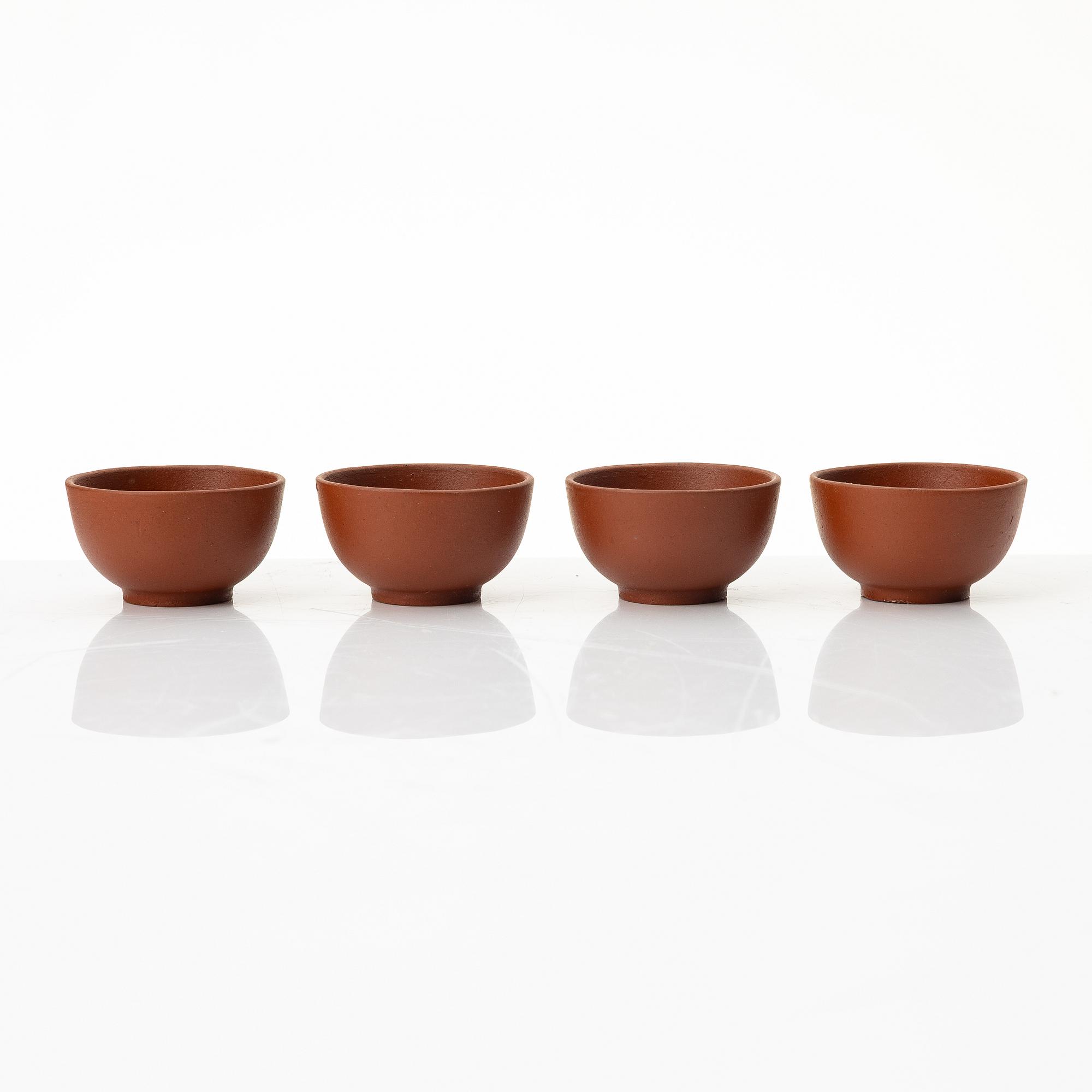 A six part red yixing Gongfu set; teapot, four cups and a tray, China, 1980s.