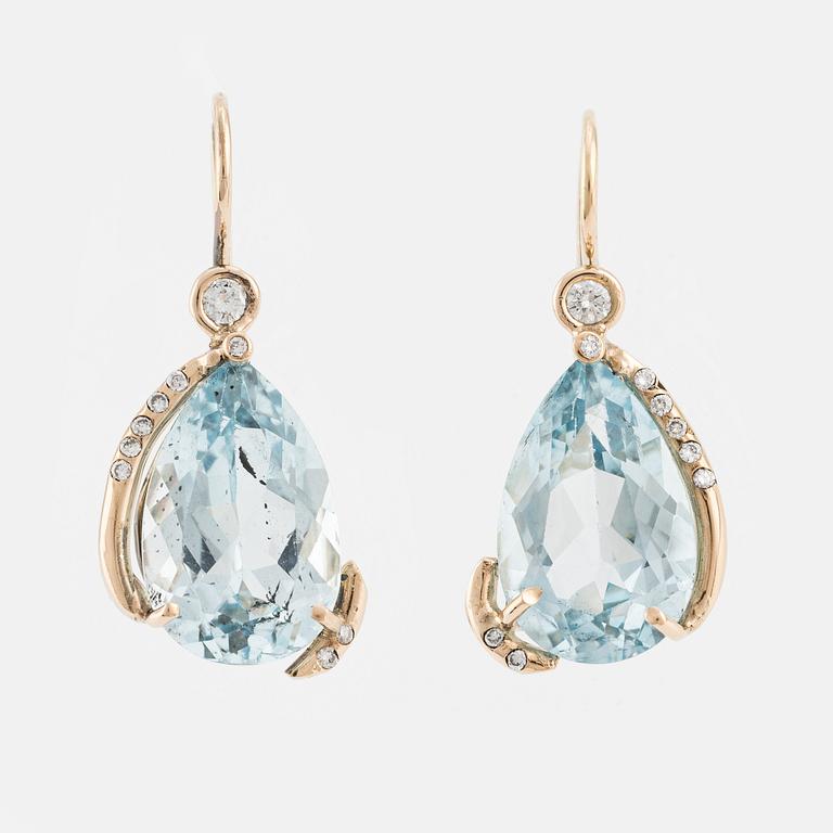 Earrings with drop-shaped faceted blue topazes and brilliant-cut diamonds.