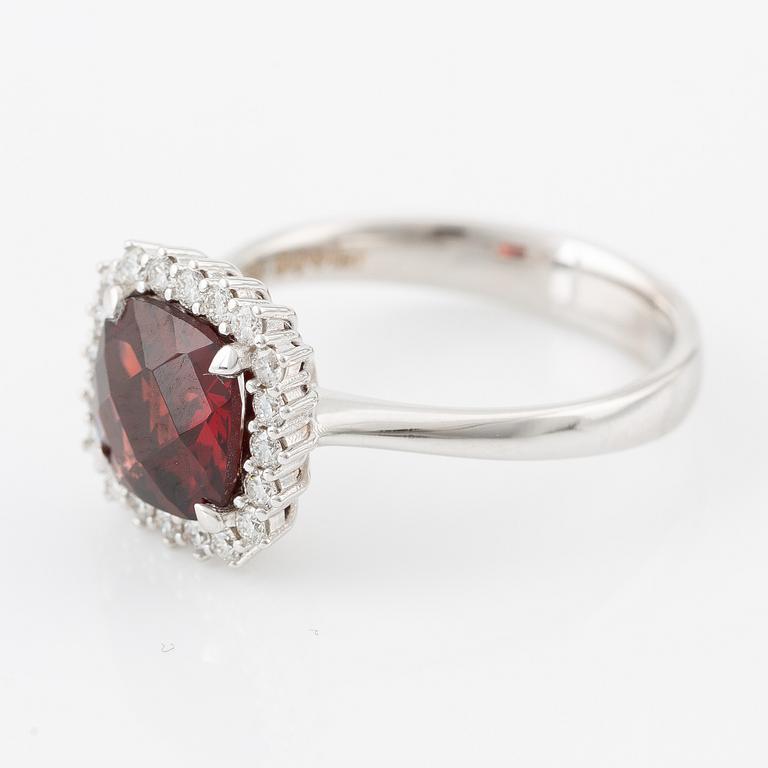 Ring in 18K gold with a faceted garnet and round brilliant-cut diamonds.