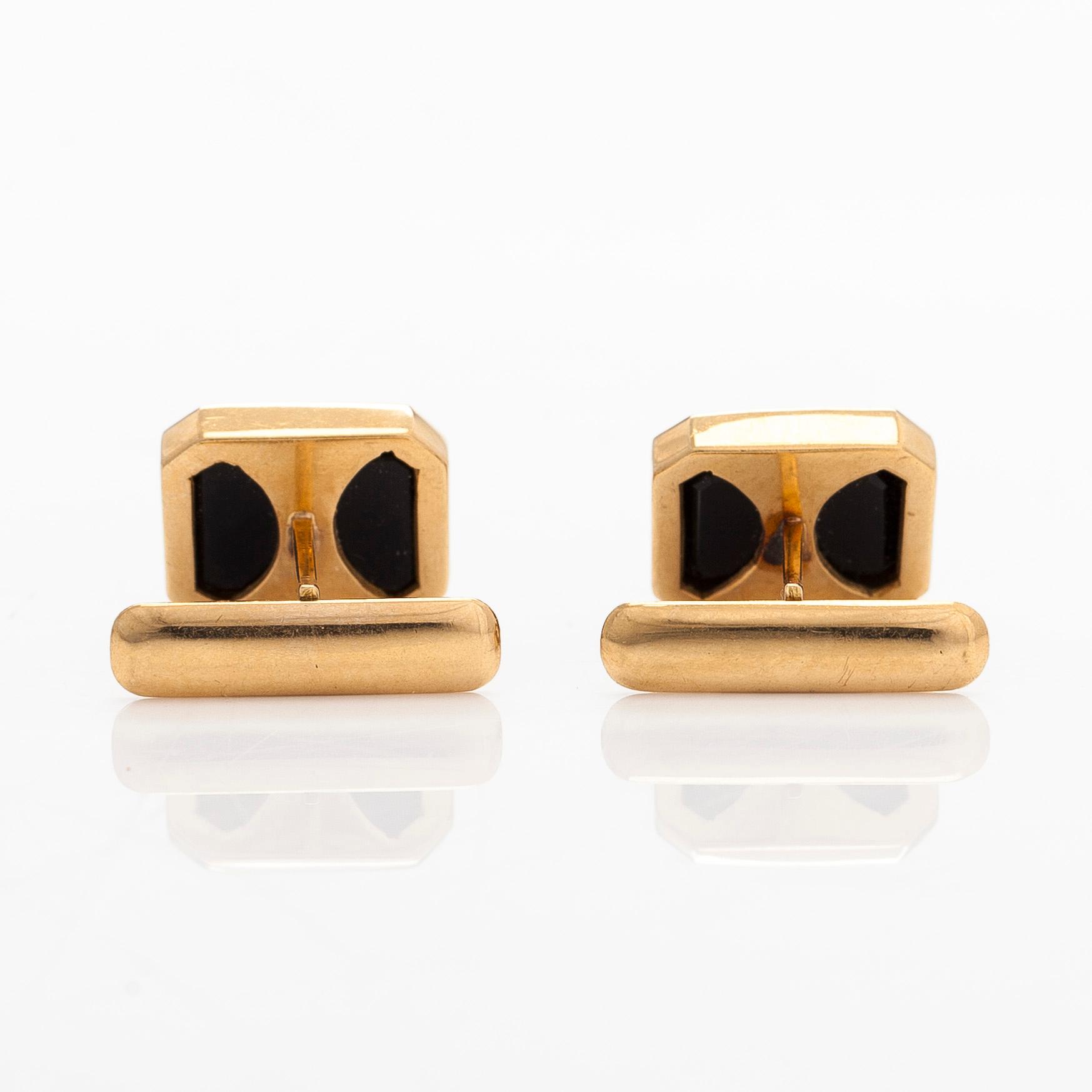 A pair of cufflinks and three shirt buttons,  18K gold and onyx.
