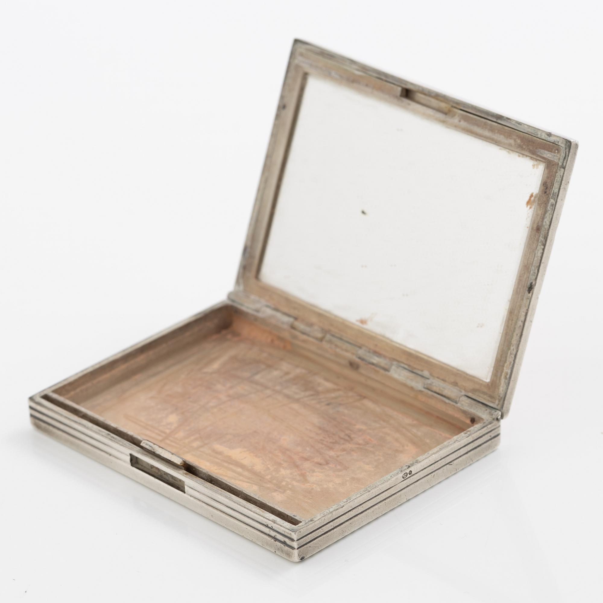 Puderdosa, silver samt guld. Med dekor av fåglar och rosa stenar.