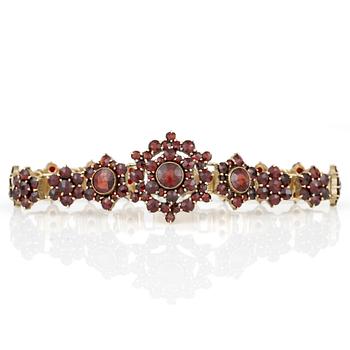 HALSBAND, ARMBAND, BROSCH samt ÖRHÄNGEN, ett par, med fasetterade granater, 1900-talets första kvartal.