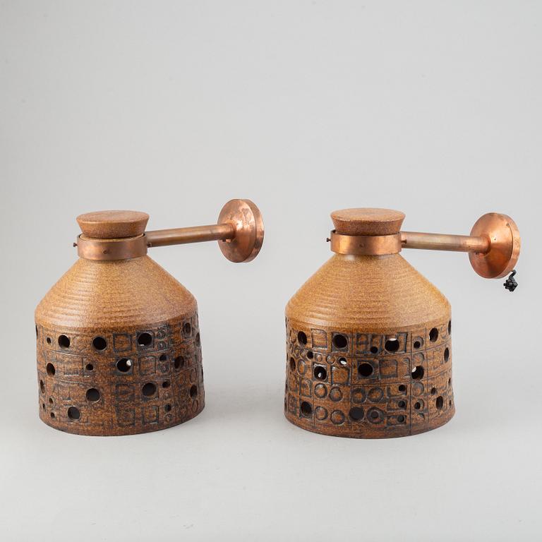 A pair of stoneware and copper wall lamps by Lisa Larson.