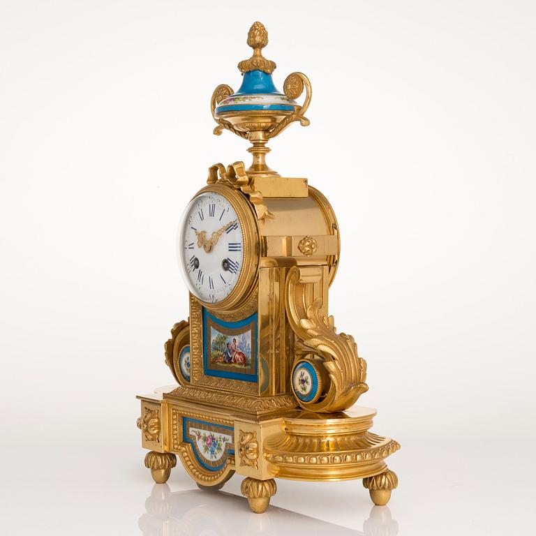 A mid-19th-century French gilt-brass mantel clock with a pair of candelabra by Dussault.