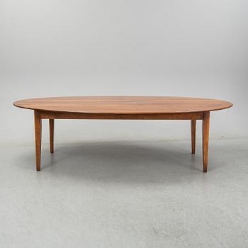 An stained oak dining table with eight chairs.