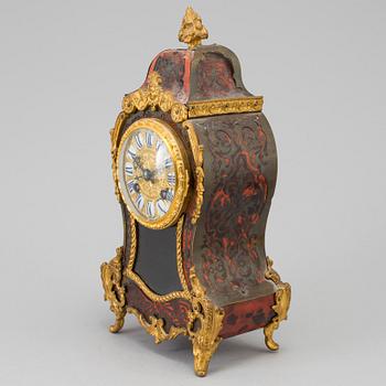 A Louis XV-style mantle clock with console base.
