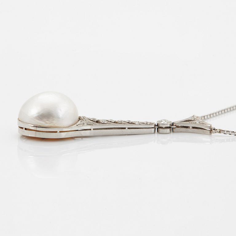 A platinum pendant set with a half pearl and old-cut diamonds.