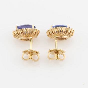 A pair of 18K gold earrings with faceted tanzanites and round brilliant-cut diamonds.