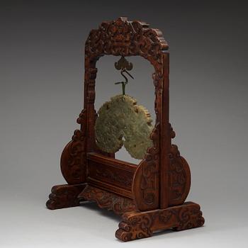 A pale spinach nephrite chime-stone with wooden stand, Qing dynasty, presumably 19th Century.