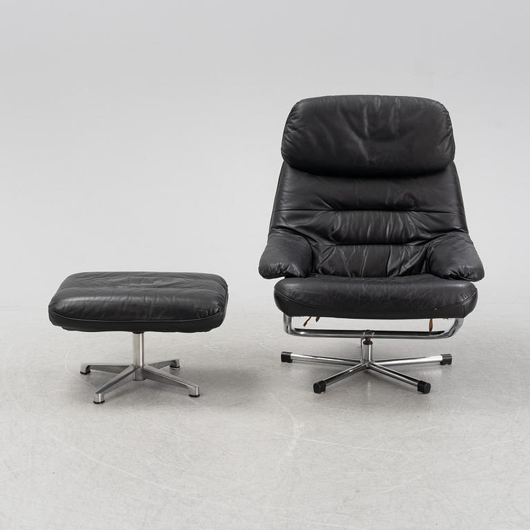 A leather and chrome lounge chair and foot stool, 1970's/80's.