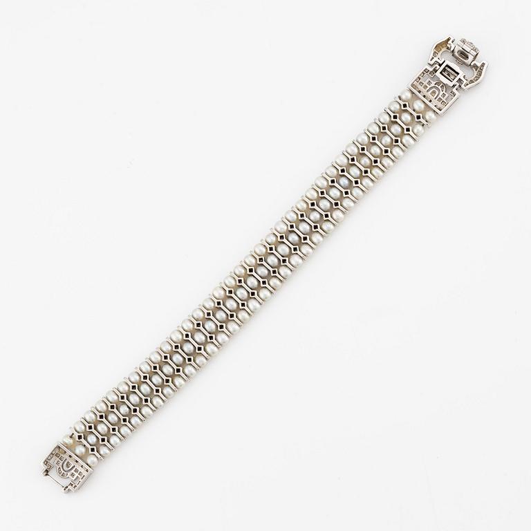 An 18K white gold bracelet set with cultured pearls and round brilliant-cut diamonds.