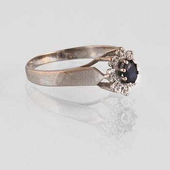 RING, 18K vitguld med fasettslipad blå safir samt 8 små åttkantslipade diamanter, kattfotstämplad. Vikt 3,5 gram.