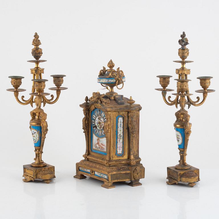 A pair of candelabras and a mantel clock, late 19th Century.