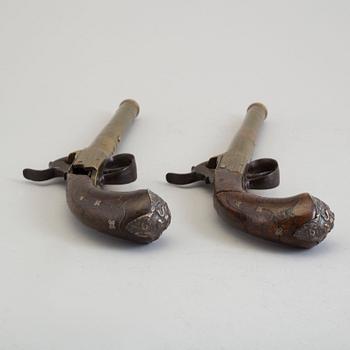 A secon half of the 19th century pair of Queen Anne brass percussion pistols converted from flintlock by Brueton, London.