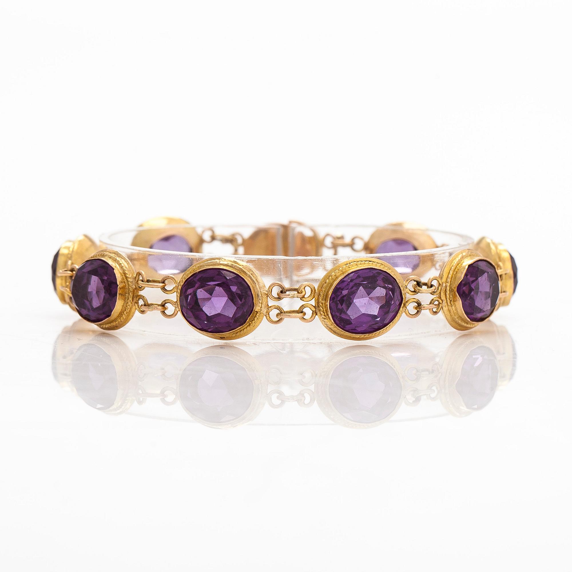 A ca. 15K gold bracelet with oval faceted synthetic sapphires.