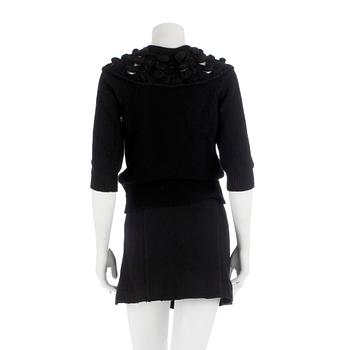 CHANEL, a black cashmere carding and a bouclé skirt.