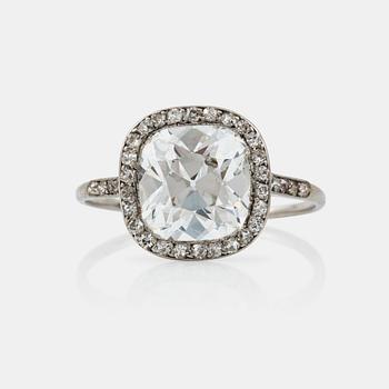 1105. RING med en äldre kuddslipad diamant ca 3.50 ct med omgivande krans av mindre diamanter, troligen tillverkad av Cartier.