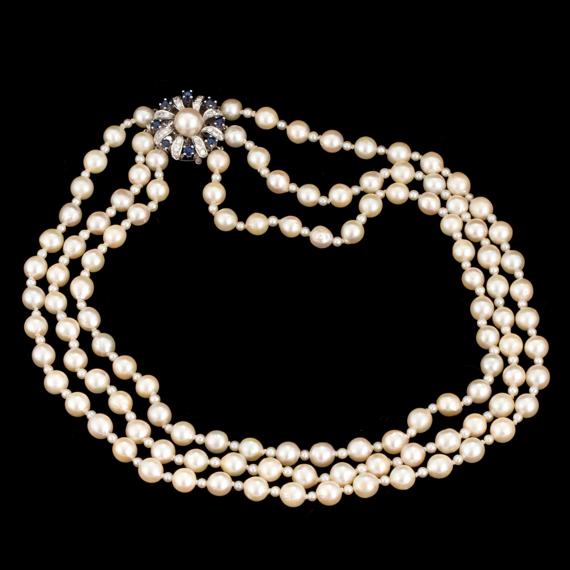 A necklace of baroque-shaped, cultured pearls with a clasp in 18K white gold decorated with diamonds and sapphires.