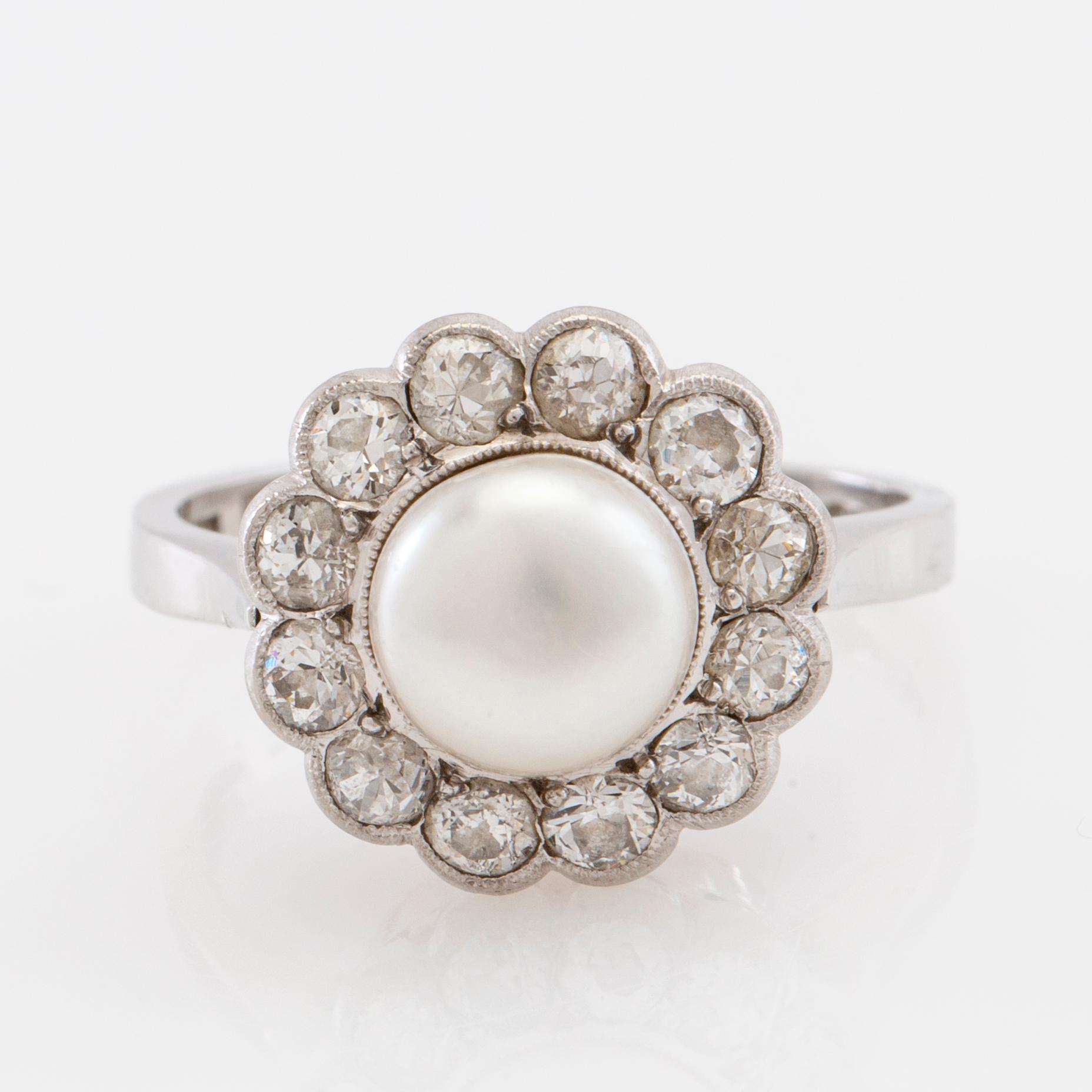 Ring in 18K white gold set with round old-cut diamonds and a cultured pearl.