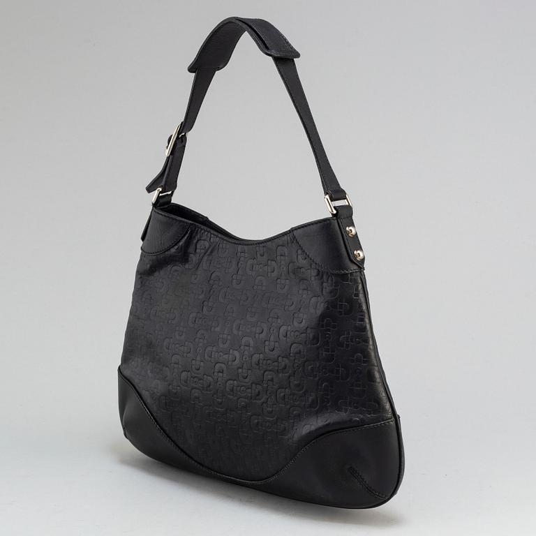GUCCI, a black leather handbag.