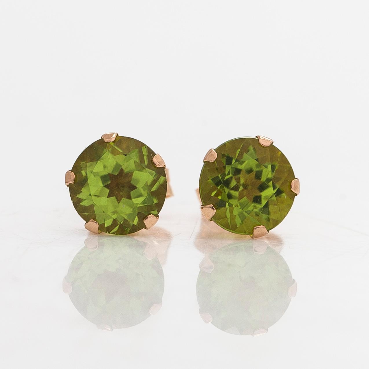 A pair of earrings, approx 12/14K gold with peridots.