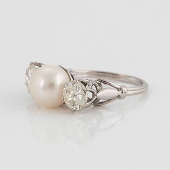 An 18K white gold ring set with a cultured pearl and two round brilliant-cut diamonds.