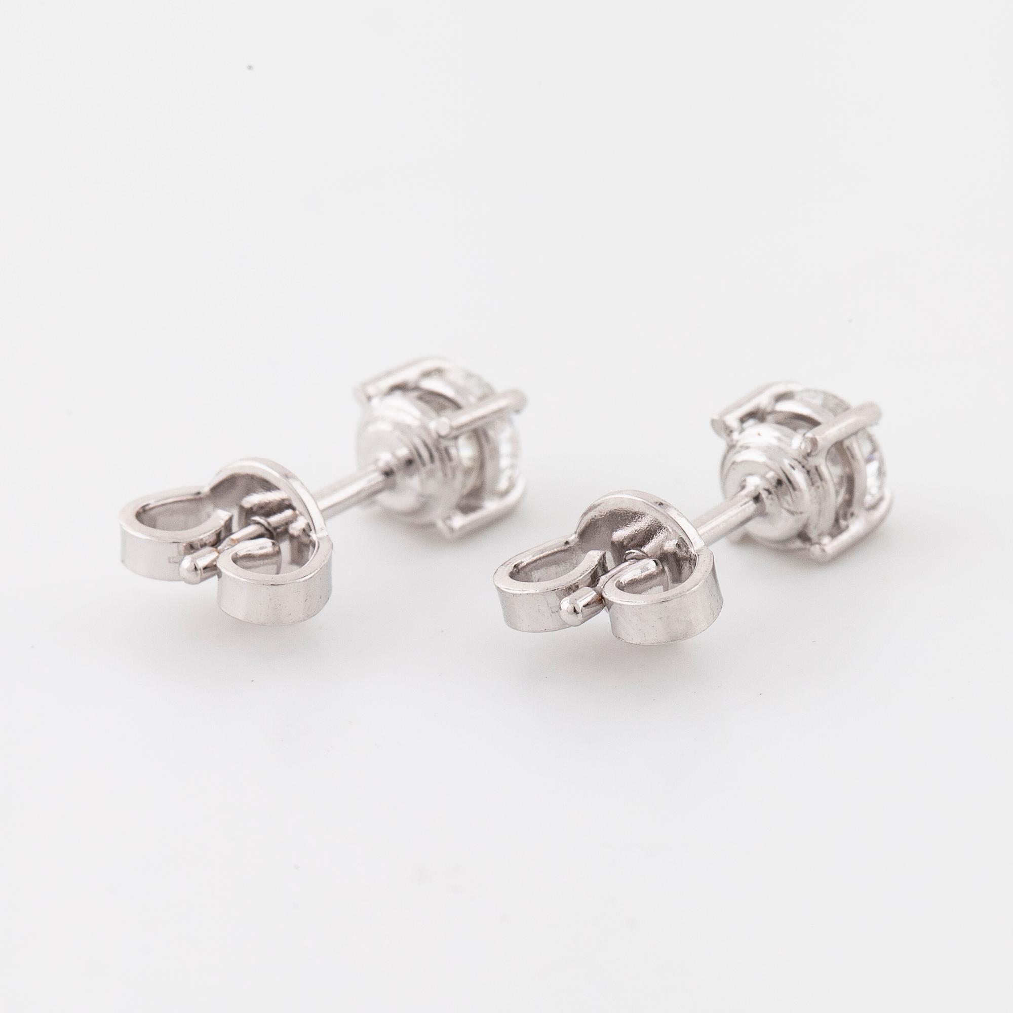 A pair of brilliant cut diamond earrings.