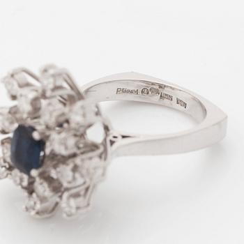 An 18K white gold ring set with a faceted sapphire and old-cut diamonds.