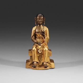 218. A part-gilt bronze figure of a Lohan, presumably Kalika, Tibeto-Chinese, 18th Century.