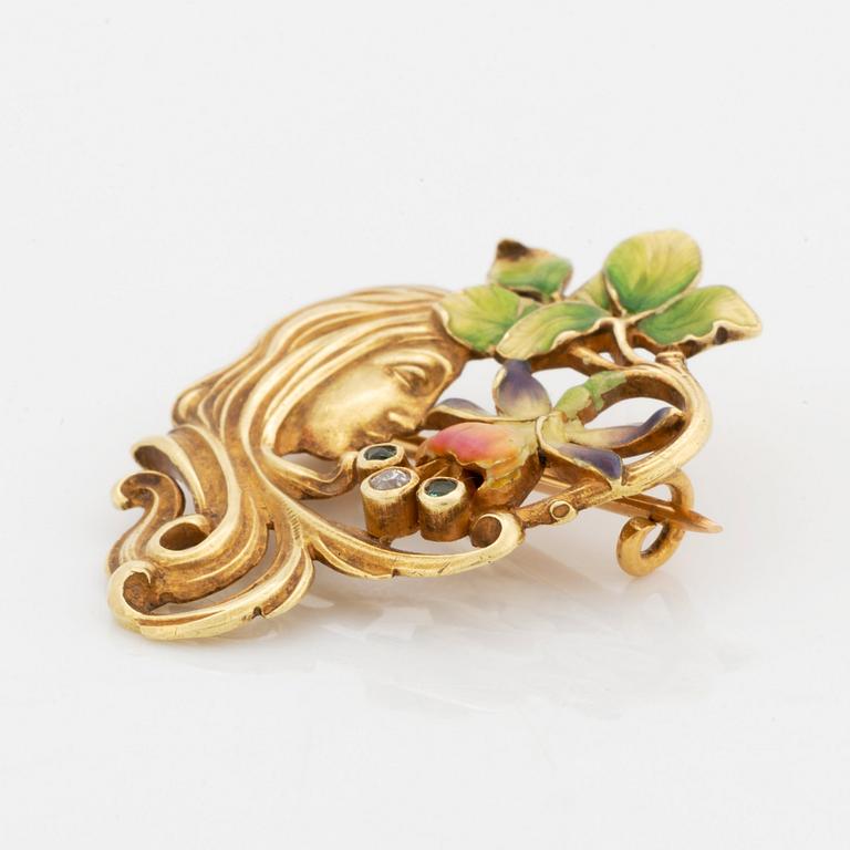 An 18K gold and enamel brooch set with an old-cut diamond and green stones.