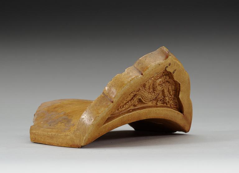 A yellow glazed end-tile, with dragon in relief, Ming dynasty (1368-1644).