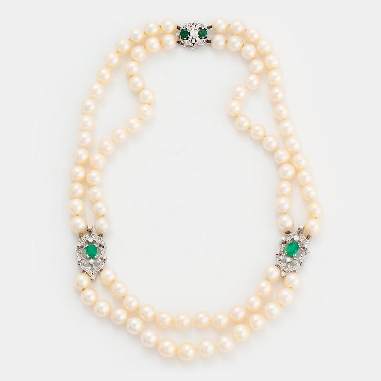 A two strand cultured pearl necklace clasp in 18K white gold set with a faceted emerald.