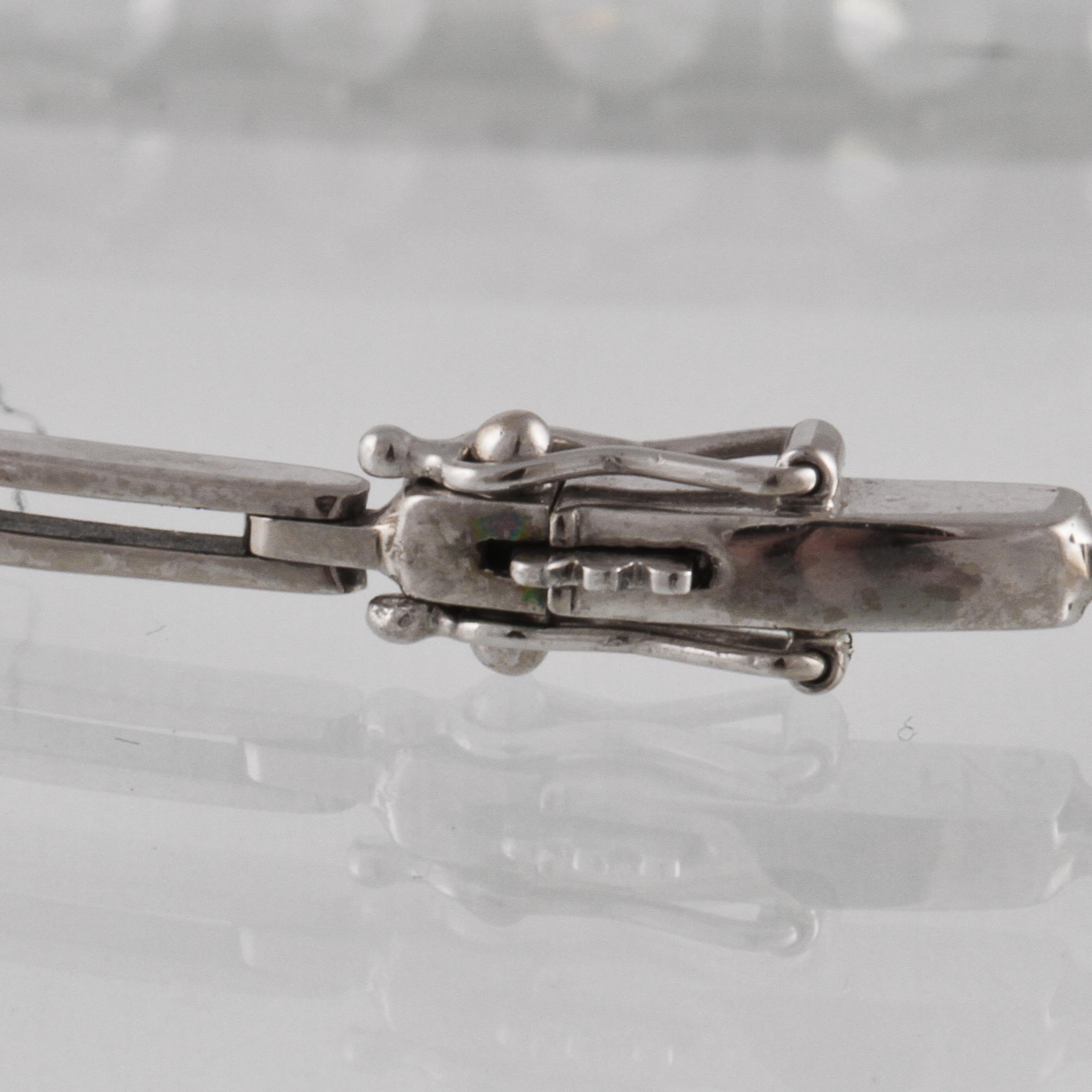 ARMLÄNK, vitguld med 9 briljantslipade diamanter, ca 0.99 ct,  Gustav Dahlgren & Co, Malmö, 1955. Vikt 9,8 gram.