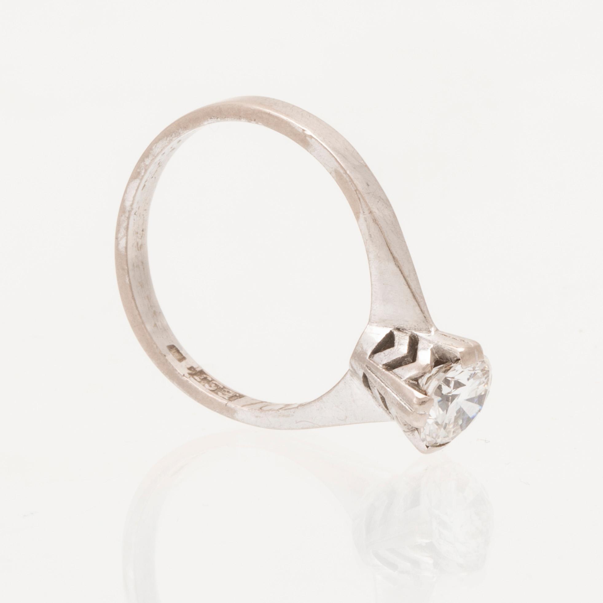 An 18K white gold solitaire ring set with a round brilliant cut diamond.