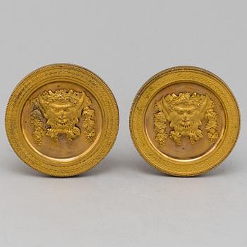 A pair of empire burnt gilt curtain holders, first half of the 20th century.