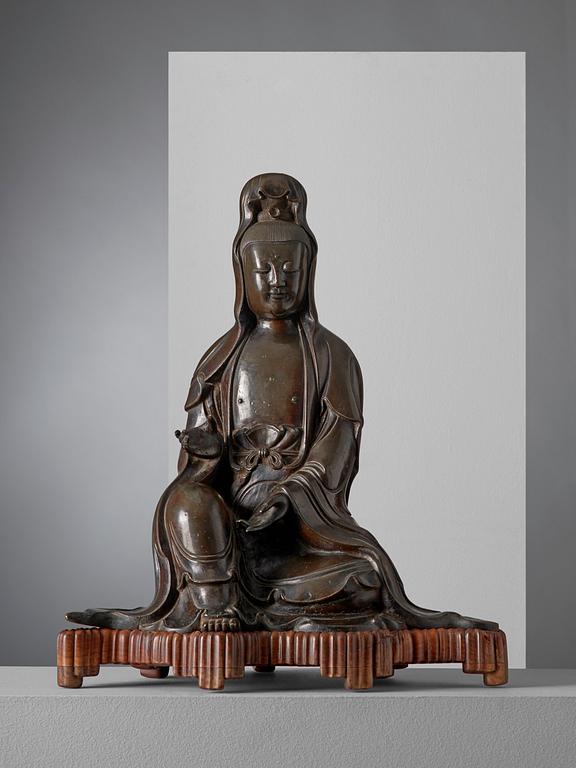 A large bronze figure of a seated Guanyin dressed in a flowing robe, Ming dynasty, 17th century.