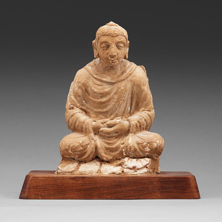 A stucco figure of a seated buddha, Gandhara, 2nd/3rd Century.